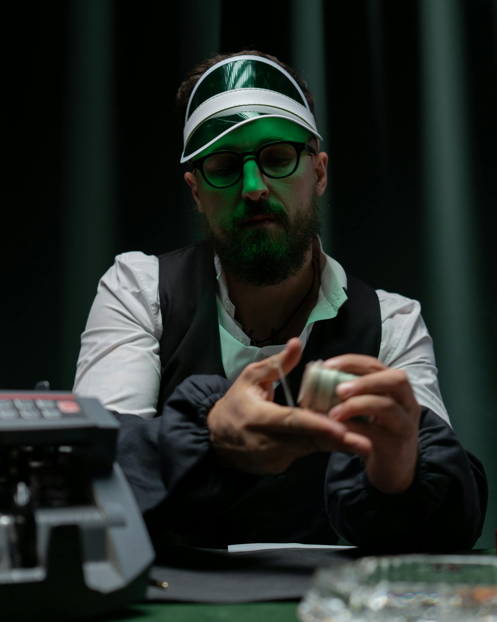 A poker dealer managing chips with a calculating machine at a gambling table.